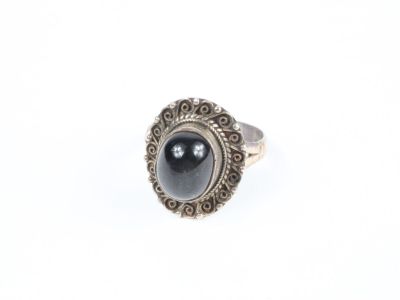 un gros plan d'une bague contenant une pierre noire