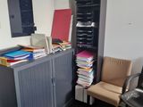 a desk with a chair and a bookcase in the corner