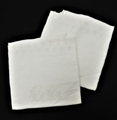 deux serviettes blanches posées sur une surface noire, sur fond noir