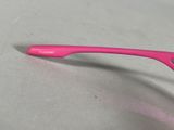 a pink toothbrush sitting on a table with a pink handle