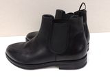 a close up of a pair of black boots on a white surface