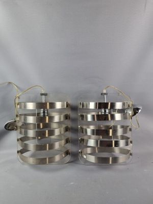 pair of stainless steel pans with lids and handles on a white background