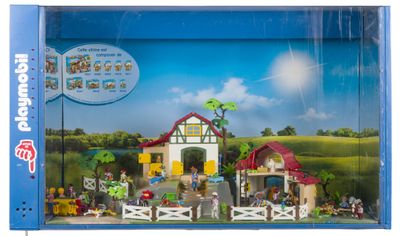 un ensemble Playmobil dans une boîte en plastique posé sur une surface blanche