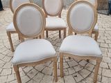 six chairs with white upholstered seats are arranged in a circle