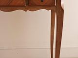 a small wooden table with two drawers on it