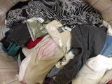a pile of clothes in a basket on a bed