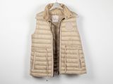 une photo d'un gilet en duvet beige suspendu à un cintre