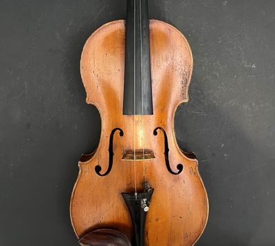 un violon accroché au mur à côté d'une paire de chaussures