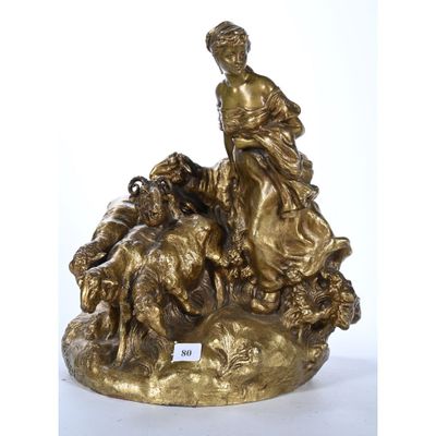 une image représentant une statue en bronze d'une femme assise sur un rocher