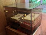 a glass display case with cigars on top of it