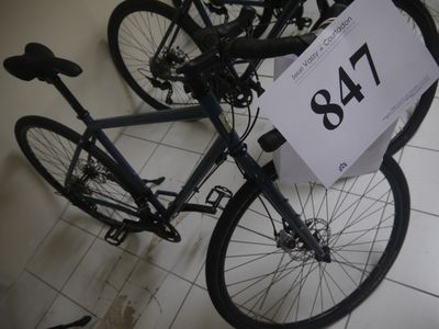 un vélo posé par terre, avec une étiquette de prix accrochée dessus