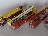 several toy fire trucks are lined up on a white surface
