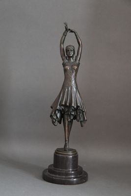 bronze statue of a woman holding a tennis racquet in one hand and a tennis ball in the other