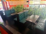 tables and benches in a restaurant with plants in the background