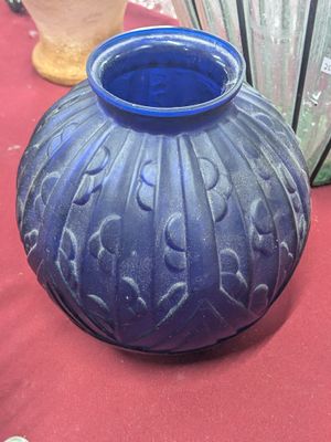 a blue vase sitting on a table with other vases in the background