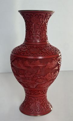 un vase rouge posé sur une table