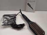 a hair brush that is sitting on a table next to a package
