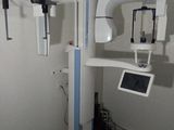 une photo d'une salle d'examen médical avec un écran accroché au mur