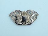 an image of a silver brooch with a black stone in the center