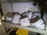 many plates and pans on a shelf in the kitchen