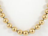 gold bead necklace on a white background with a gold clasp