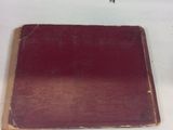 a red book on a white surface with a small insect on it
