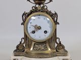 une horloge en or posée sur un socle en marbre