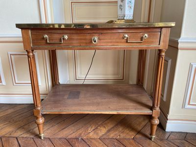 une table en bois avec un plateau en marbre posée sur un parquet en bois massif
