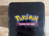 a black pokemon trading card game box sitting on top of a wooden table