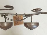 a metal object hanging on a wall next to a vase