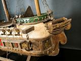 a wooden model of a boat on display in a museum