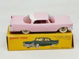 pink toy car sitting on top of a box on a white surface