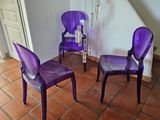 trois chaises violettes dans une pièce au sol carrelé de rouge