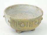 a small bowl with holes in it on a white surface