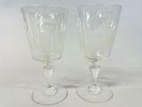 two wine glasses sitting next to each other on a table
