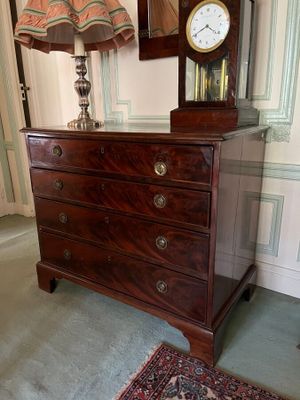 a dresser with a clock on top of it in a room
