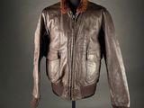 une veste en cuir marron à col en fourrure, posée sur un mannequin