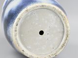 a blue and white vase with a hole in it