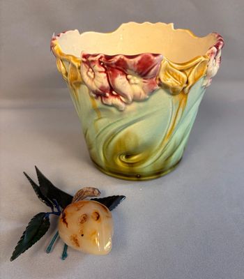 a small vase with a flower on it next to a small flower