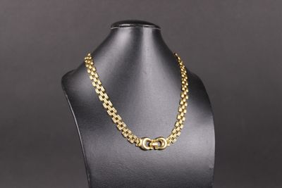 un collier à chaîne en or sur un mannequin, sur fond noir