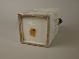 a small white box with a small piece of paper in it