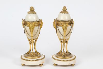 pair of white and gold vases on pedestals on a white background