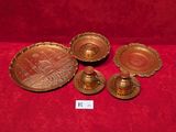 three brass candlesticks and a tray with a picture on it