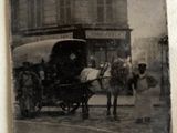 an old photo of a horse pulling a carriage down the street