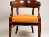 une chaise en bois avec une assise en cuir orange sur fond blanc
