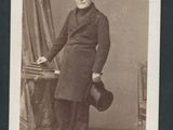 une vieille photo d'un homme en manteau et chapeau