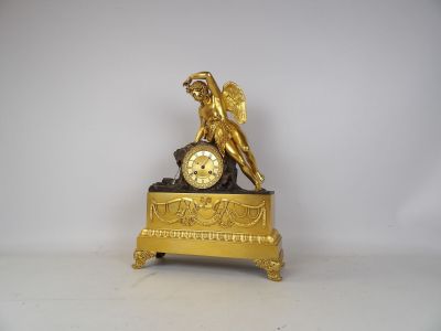 a gold clock with a statue on top of it