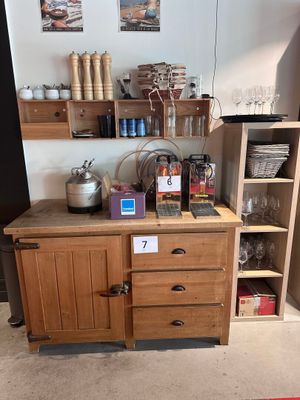 une petite cuisine avec un placard en bois et une cafetière