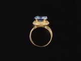 a gold ring with a blue stone in the center