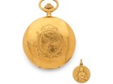 an antique gold pocket watch with a medallion on the front